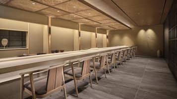 Una larga recepción de madera con sillones acolchados en un vestíbulo moderno y bien iluminado.