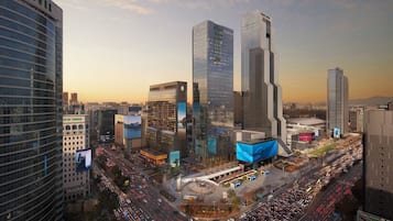 A cityscape with modern high-rise buildings, a busy intersection, and a large billboard.