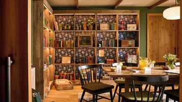 Eine gemütliche Leseecke mit Bücherregal, Holztisch und zwei Stühlen.
