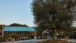 A restaurant with a glass roof and outdoor seating area. - Treehouse Hotel Silicon Valley (Sunnyvale)