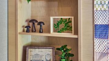 Une étagère en bois ornée d’une décoration en forme de maison, d’une feuille encadrée et d’un plan technique encadré.