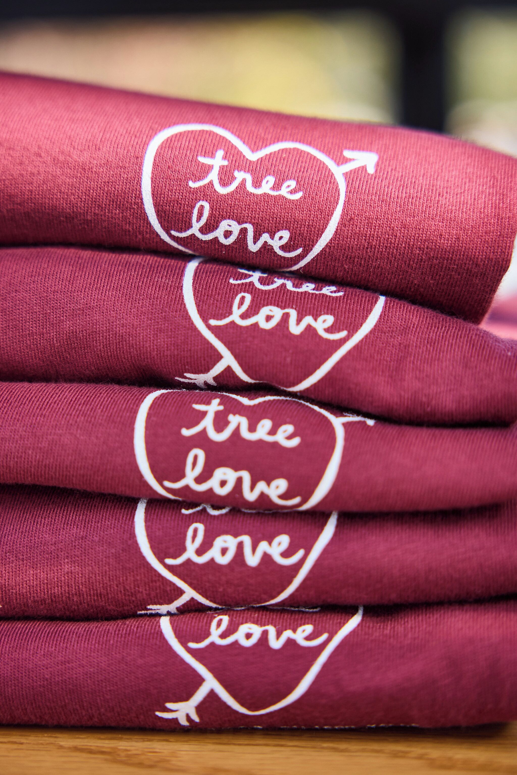 A stack of red fabric items with embroidered text.