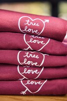 A stack of red fabric items with embroidered text.