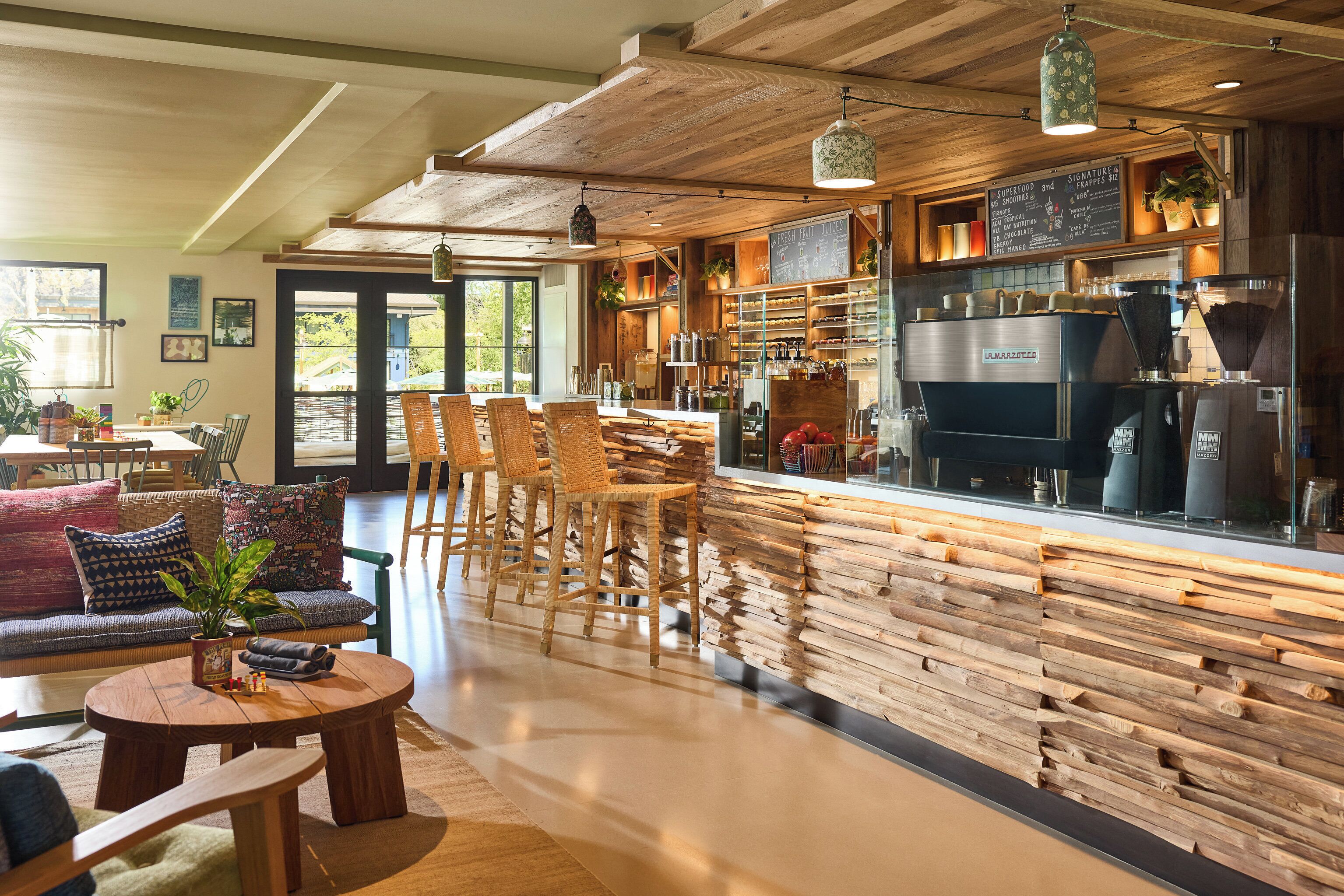 A cozy cafe with wooden furniture, a bar area, and a coffee machine.