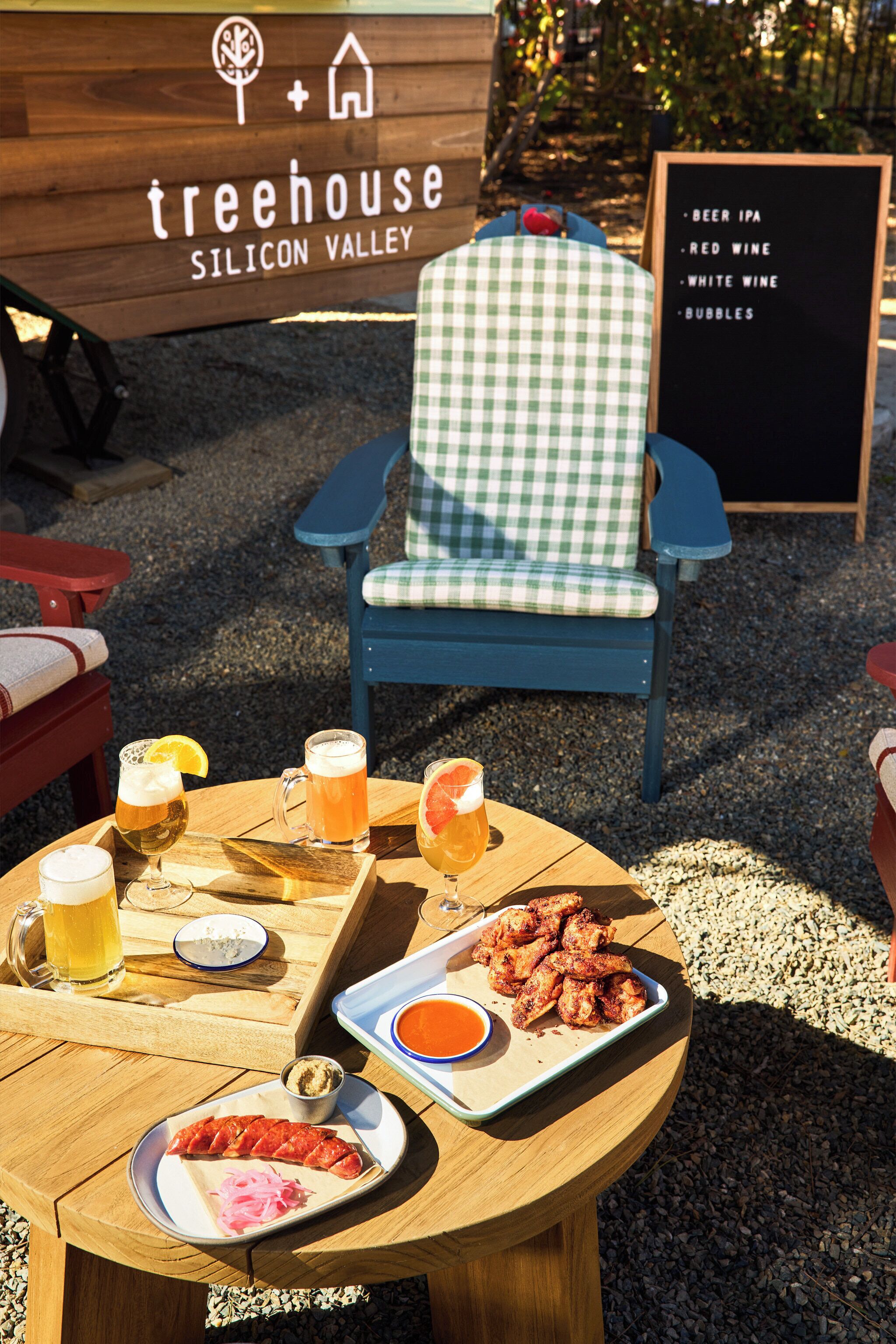A table with food and drinks, a checkered chair, and a sign for Treehouse Silicon Valley.