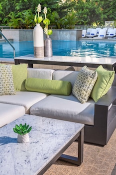 Outdoor pool, sun loungers at Hilton Garden Inn Waikiki Beach