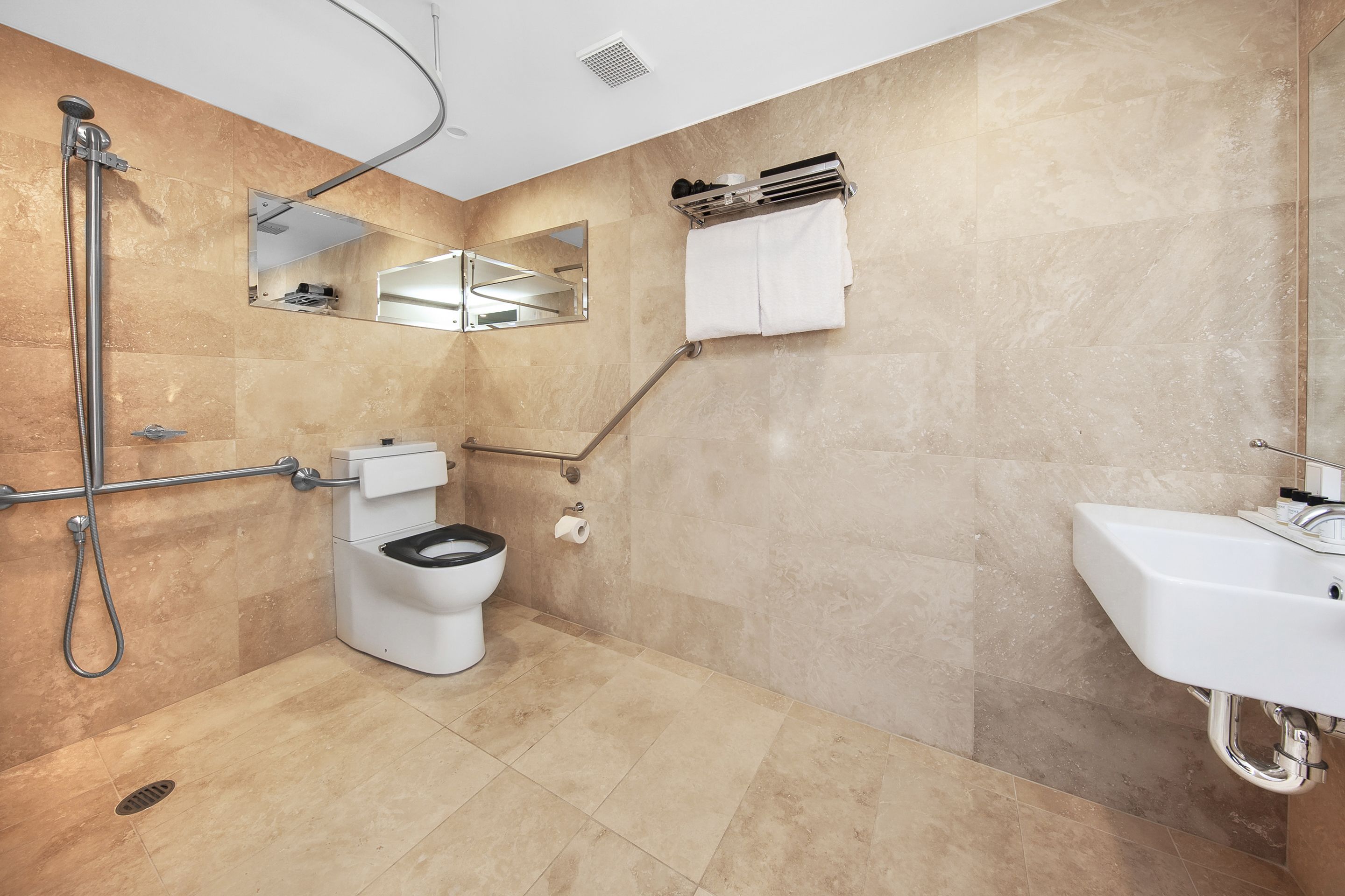 A modern bathroom with a shower, toilet, and sink.