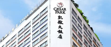 Un hotel de gran altura con un llamativo letrero que dice "Cesar Park", múltiples balcones y un diseño arquitectónico moderno.