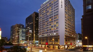 A high-rise hotel with multiple floors, a prominent entrance, and illuminated windows.