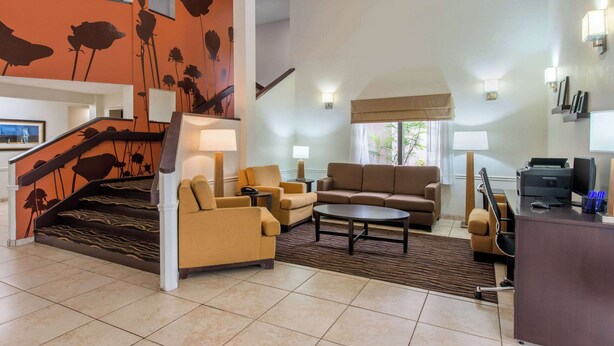 A spacious living area with a staircase, a sofa set, a coffee table, and a desk with a printer. - Sleep Inn Sarasota North (Sarasota)