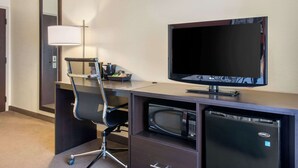 A hotel room with a desk, chair, television, microwave, and refrigerator. - Sleep Inn Sarasota North (Sarasota)