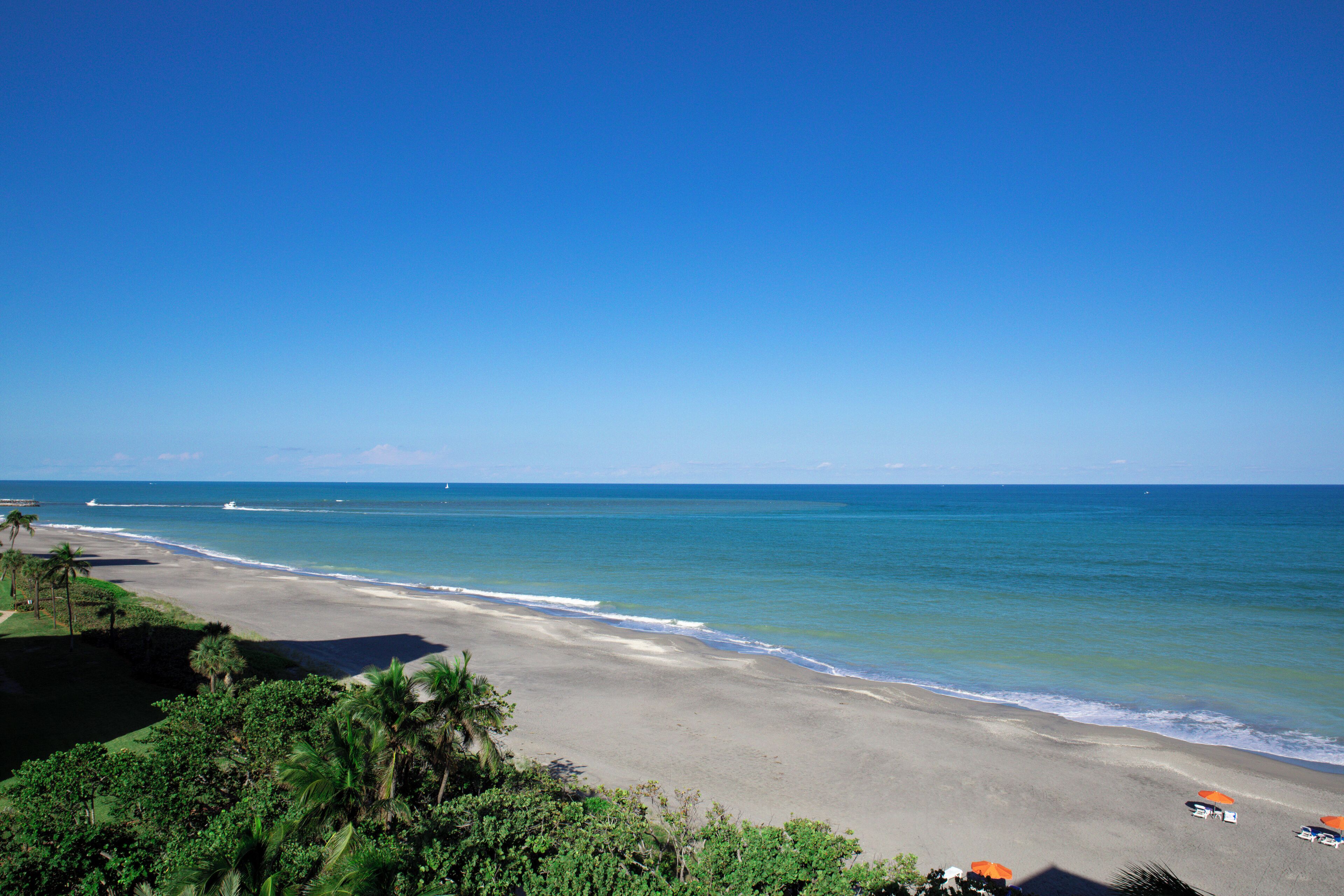 A beach with a clear view of the ocean and a sandy shoreline.