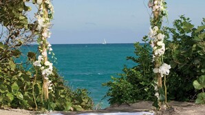 A beach wedding arch with white flowers and greenery, overlooking the sea. - Jupiter Beach Resort & Spa (Jupiter)
