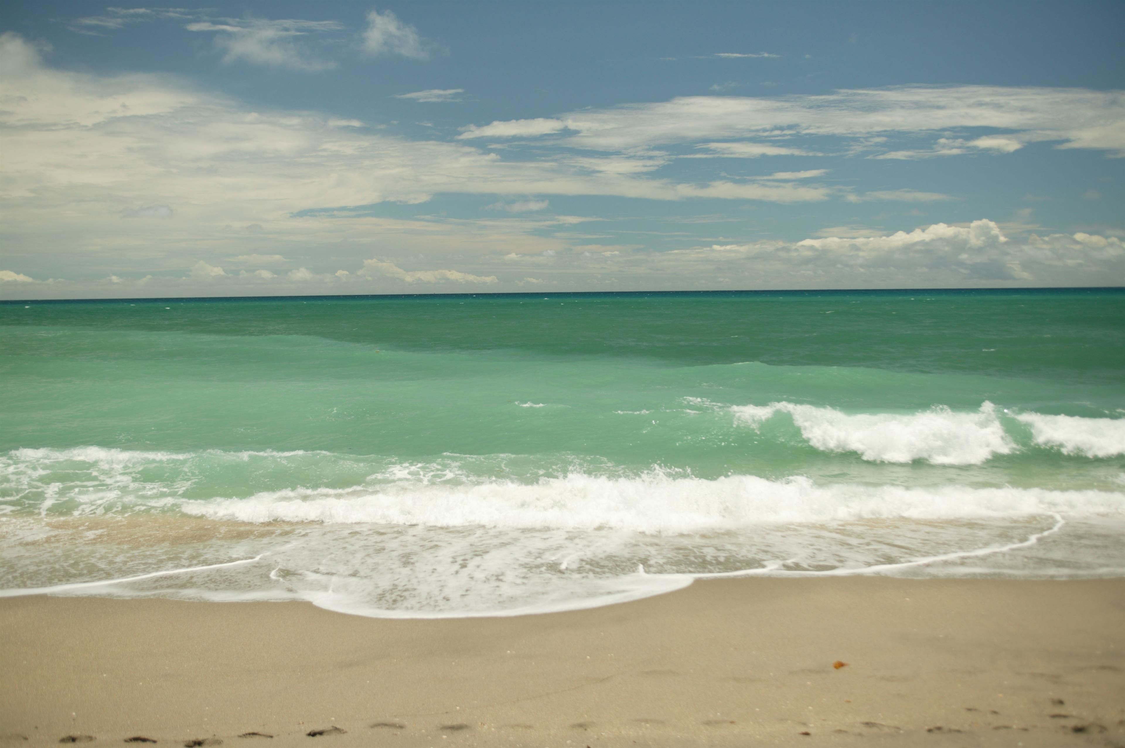 Una playa con agua turquesa cristalina y olas suaves.