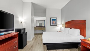 A hotel room with a bed, a TV, a desk, and a microwave. - Quality Inn Weeki Wachee - Spring Hill (Brooksville)