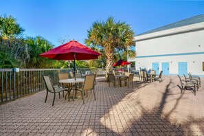 Una piscina al aire libre, sombrillas, sillones reclinables de piscina
