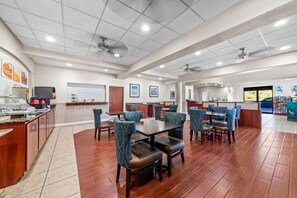 A spacious dining area with high ceilings, recessed lighting, and a mix of seating arrangements including booths and tables.