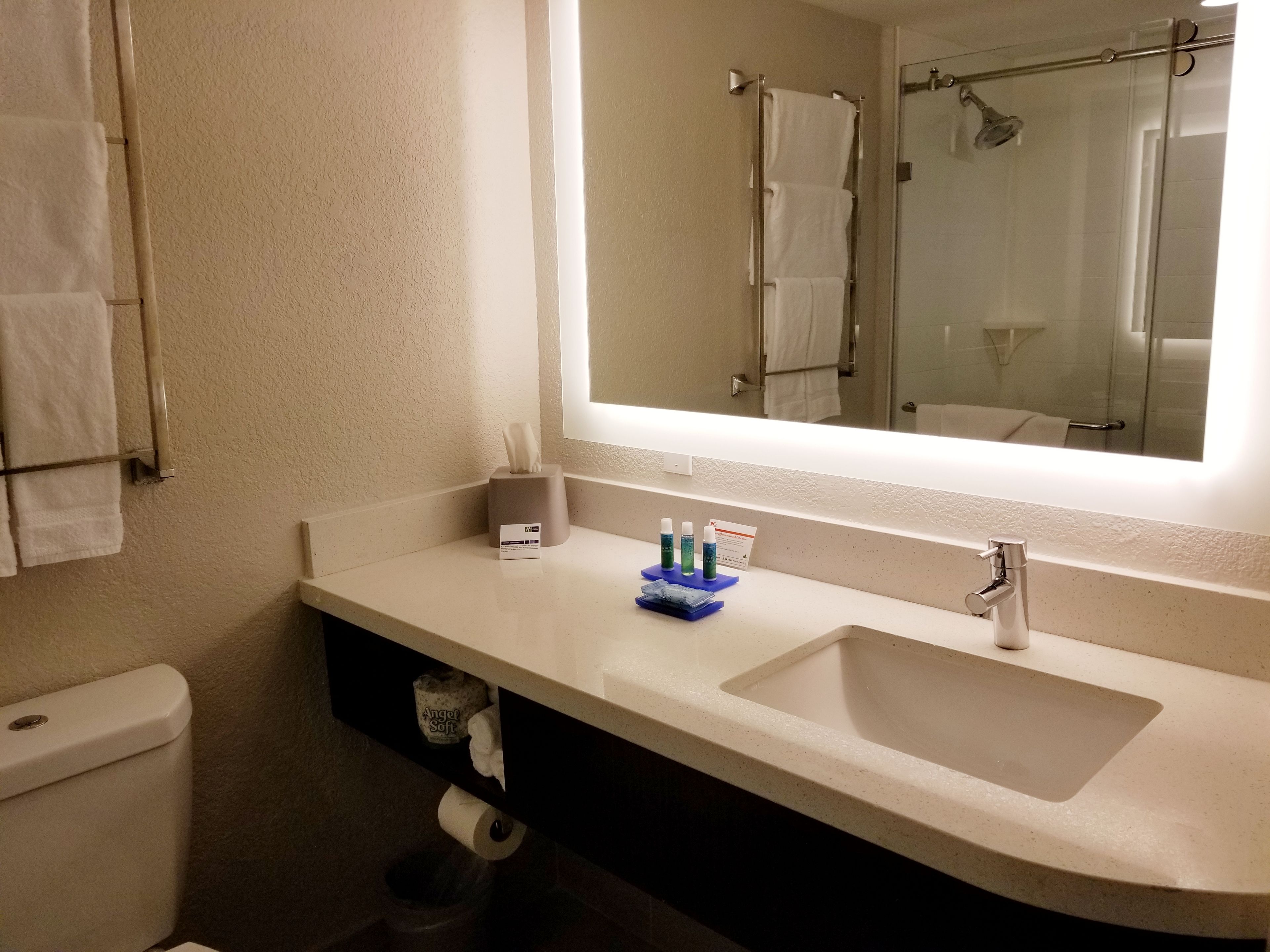 A bathroom with a sink, mirror, and towel rack.