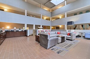 A spacious, multi-level living area with a kitchen, sofas, and a dining table.