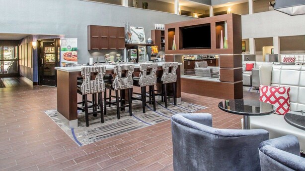 A modern interior with a bar area, seating, and a flat-screen TV. - Quality Suites Nashville Airport (Nashville)