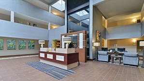 A spacious lobby with a reception desk, seating area, and artwork on the walls. - Quality Suites Nashville Airport (Nashville)