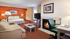 A hotel room with a bed, two sofas, a television, a fireplace, and a desk with a laptop. - Residence Inn by Marriott Santa Fe (Santa Fe)