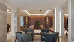 Un vestíbulo moderno con una zona de estar central, una planta grande y un diseño contemporáneo.