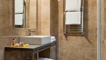 Un baño moderno con un espejo grande, un lavabo y un perchero para toallas.