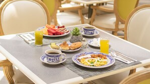A breakfast table set with plates of food, cups, and a juice glass. - iStay Hotel Ciudad Juarez (Ciudad Juárez)