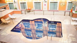 A rooftop pool area with lounge chairs and a sunbathing area. - iStay Hotel Ciudad Juarez (Ciudad Juárez)