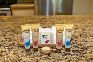 A countertop with five tubes of Hawaiian Tropic products, a bar of soap, and a coconut-shaped soap bar.