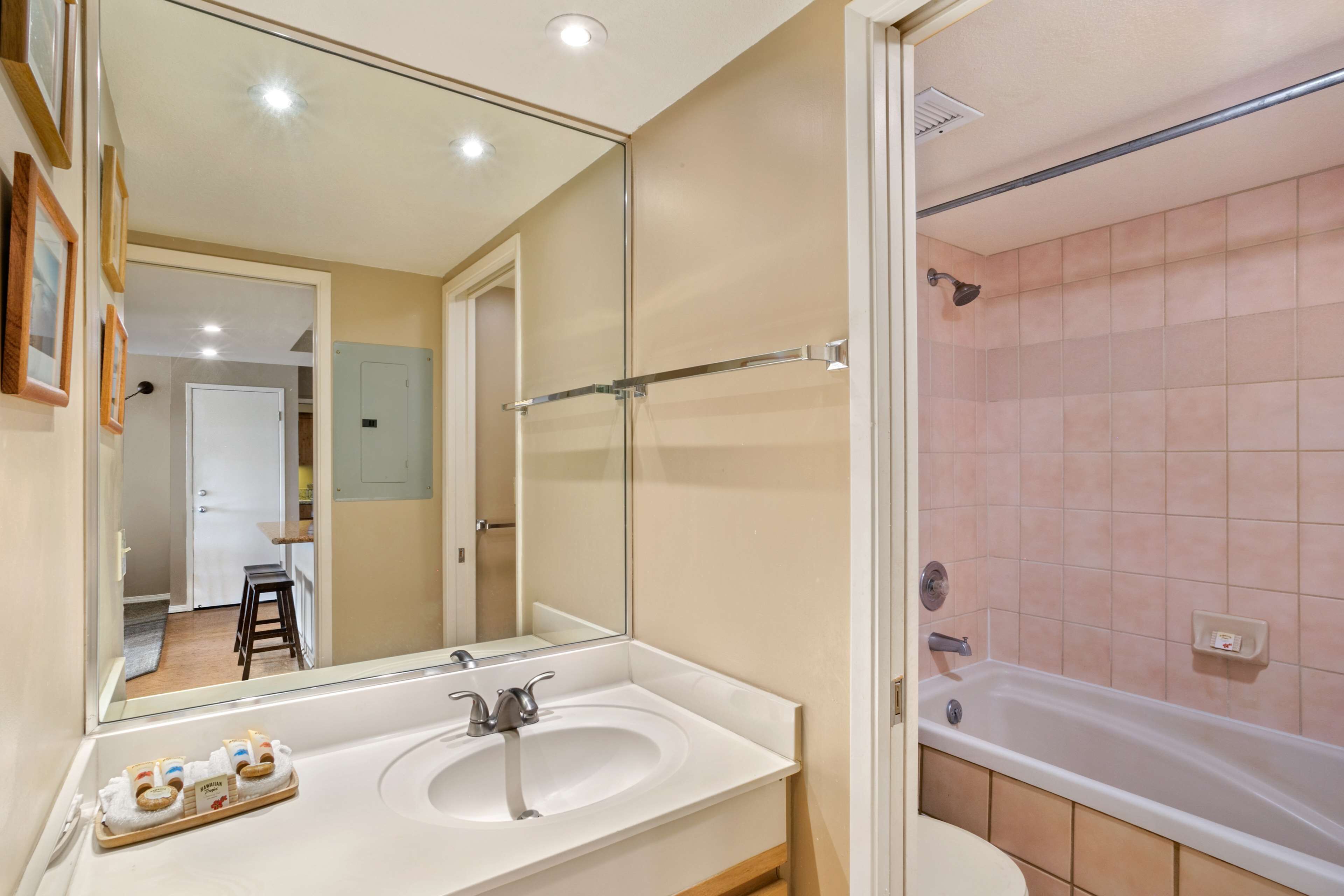 Un bagno con lavandino, specchio e vasca.