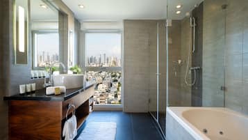 A modern bathroom with a large bathtub, a vanity with a mirror, and a view of a cityscape through a large window.