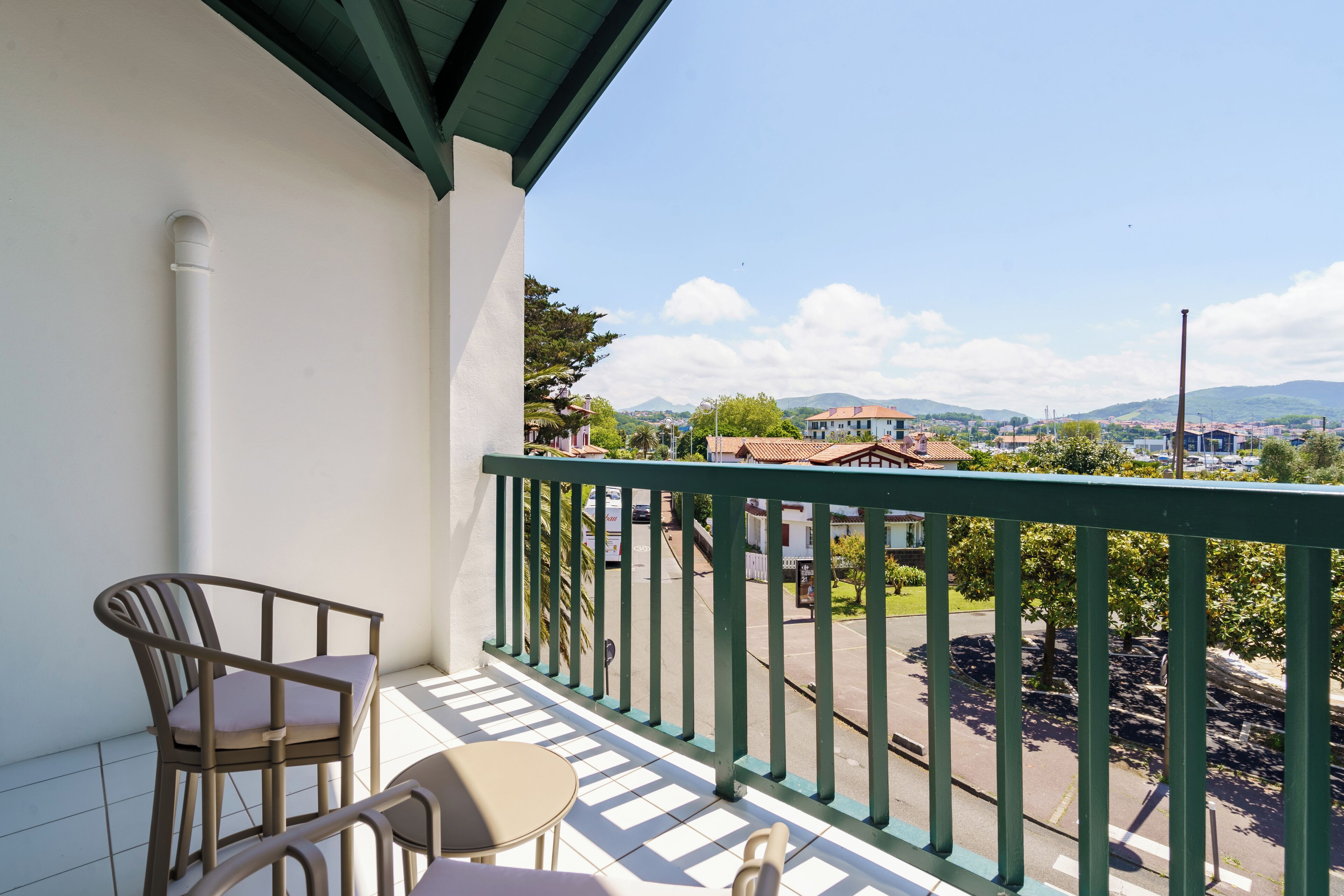 Un balcon donnant sur la ville, une chaise et une table.