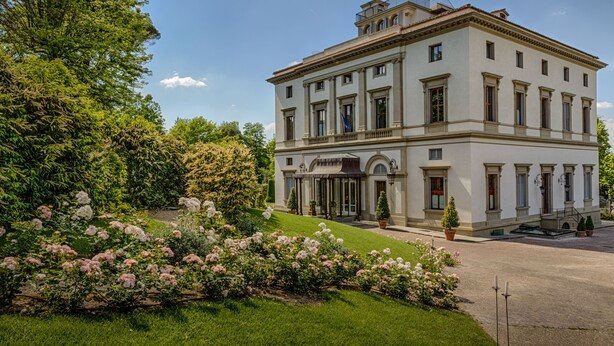 A large, classical building with a symmetrical facade, multiple windows, and a central entrance with a canopy.