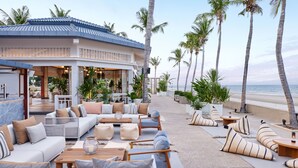 A beachfront resort with outdoor seating, palm trees, and a view of the ocean. - Dusit Thani Hua Hin (Cha-am)