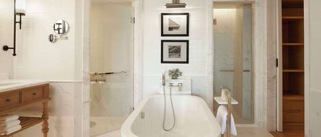 A modern bathroom with a freestanding bathtub, a vanity with a mirror, and a shower area.