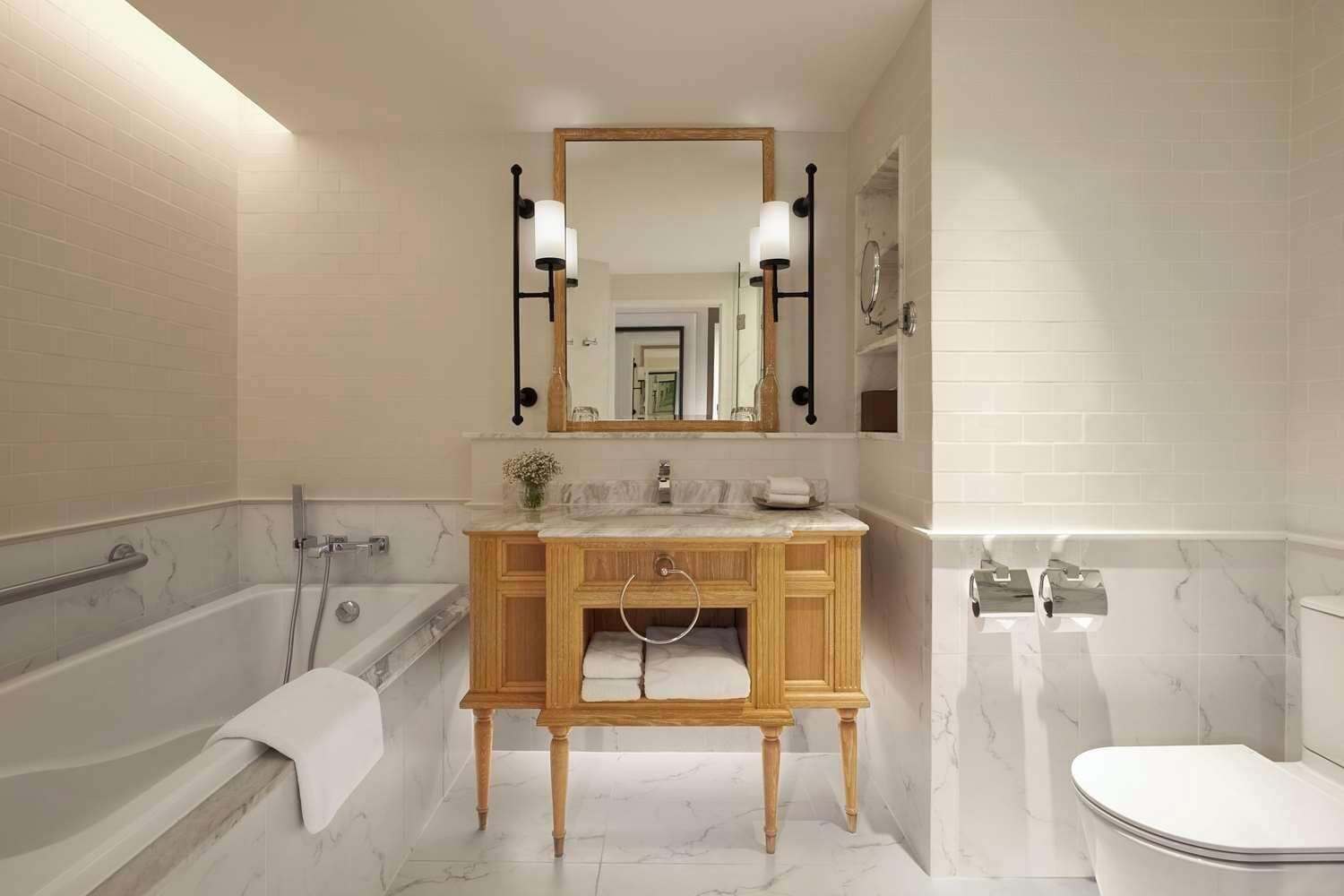 A modern bathroom with a wooden vanity, a large mirror, and a bathtub.