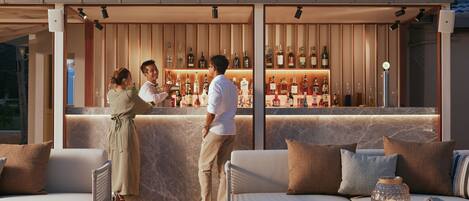 An outdoor bar area with seating, a bar counter, and a view of the sky.