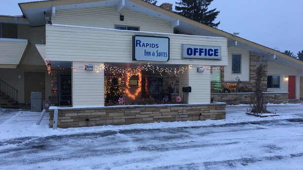 A building with a sign for 'RAPIDS INN & SUITES' and an 'OFFICE' section. - Rapids Inn and Suites (Wisconsin Rapids)