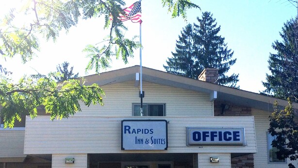 A building with a sign that reads "RAPIDS INN & SUITES OFFICE".