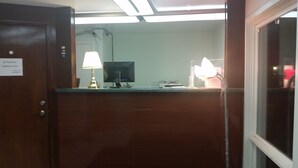A reception desk with a computer monitor, a lamp, and a sign indicating the area is for employees only. - Rapids Inn and Suites (Wisconsin Rapids)