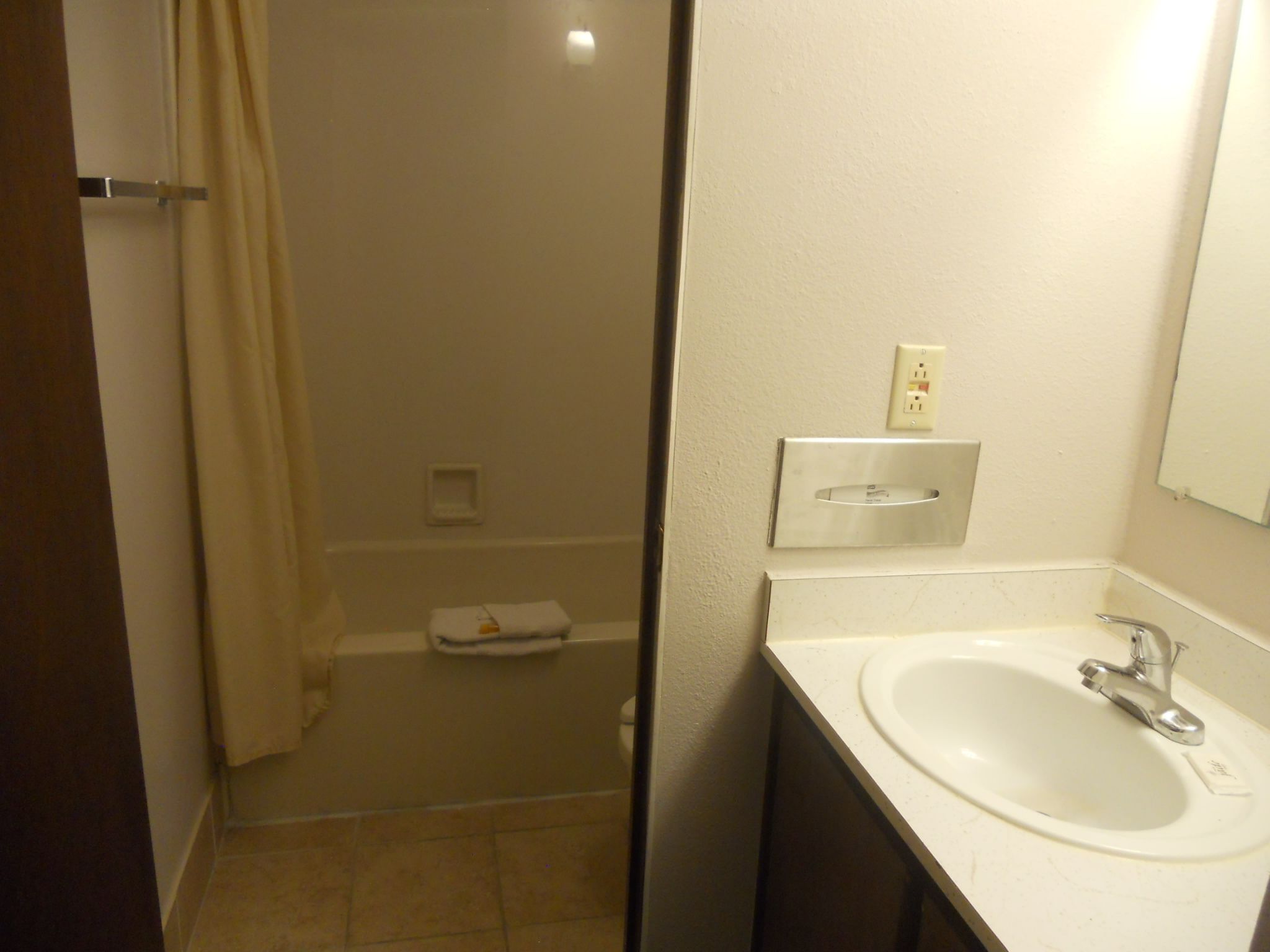 A bathroom with a white sink, a mirror, and a shower area.