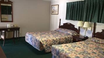Habitación de hotel con dos camas, un escritorio, una silla, un teléfono y un cuadro en la pared.