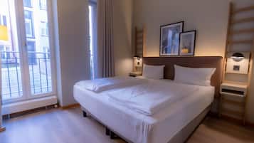 Ropa de cama hipoalergénica y caja de seguridad en la habitación