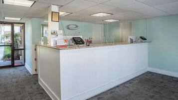 A reception area with a reception desk, a phone, and a door.
