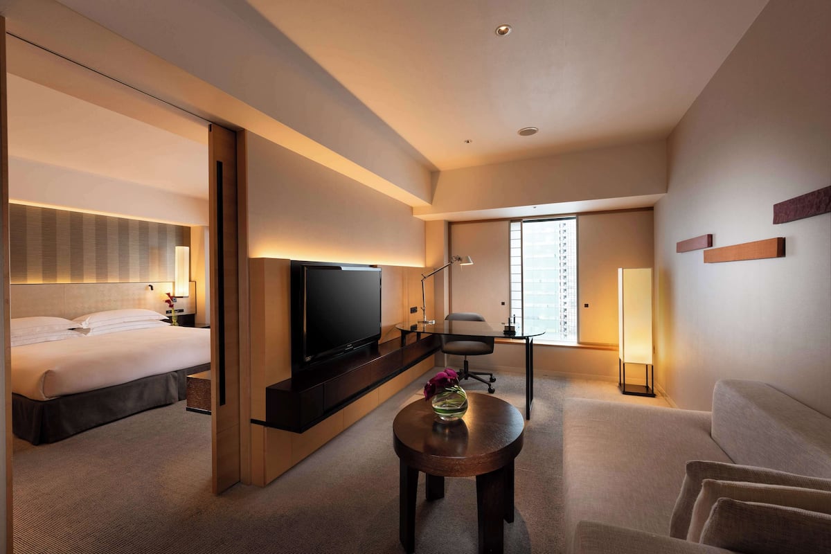A hotel room with a bed, a TV, a desk, and a chair.