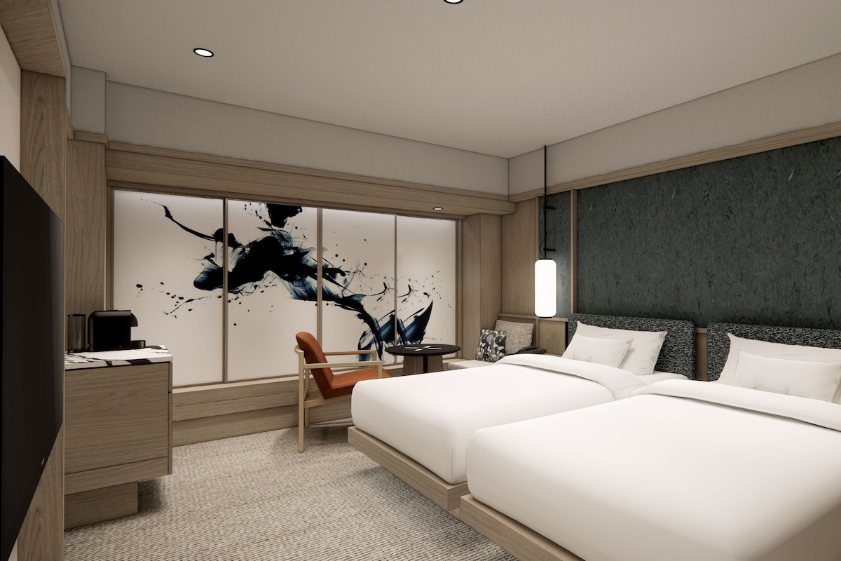 Een moderne hotelkamer met een groot bed, een bureau en een zithoek.