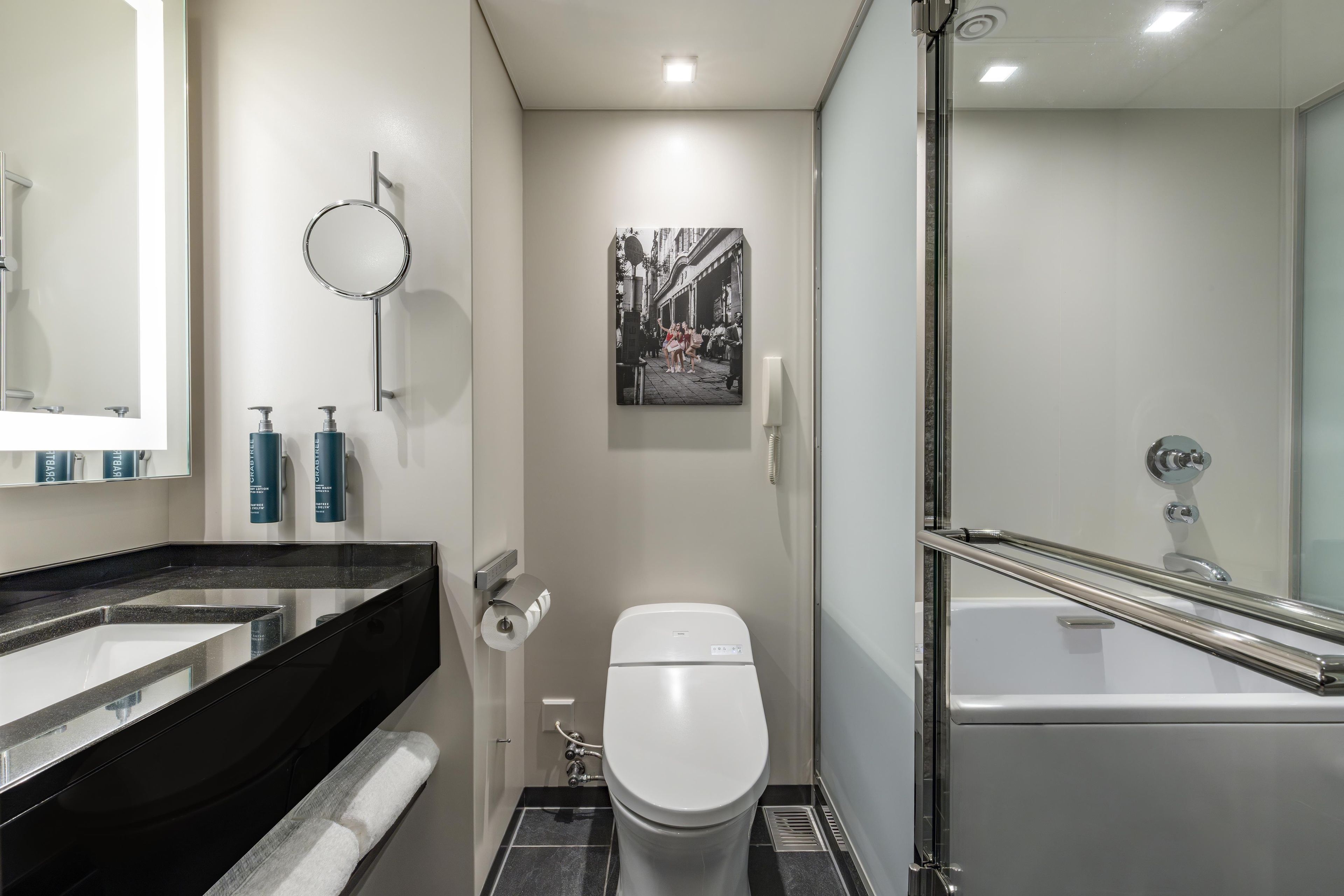 Une salle de bain moderne équipée de toilettes, d’un lavabo et d’une baignoire.