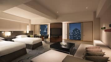 A modern hotel room with two beds, a sofa, a TV, and a city view.